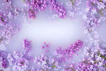 Branches of blossoming lilac float in milk. Copy space, flat lay. The concept of purity, tenderness, freshness, youth. Summer mood.