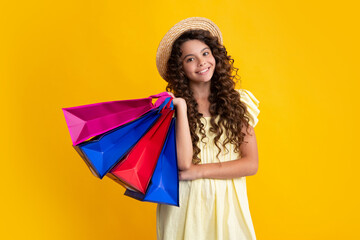 Funny teen girl hold shopping bag enjoying sale isolated on yellow. Portrait of teenager schoolgirl is ready to go shopping. Summer shopping sale.