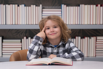 Education and school concept. Kid reading book in a book store or library,