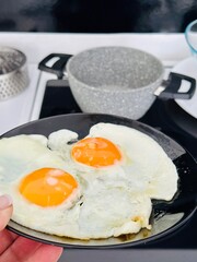 a plate in a woman's hand against the background of pots in the kitchen