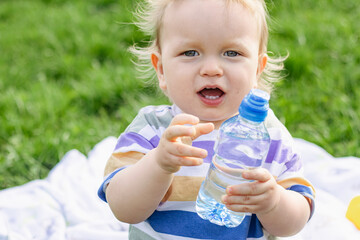 Cute little boy drinking water from bottle