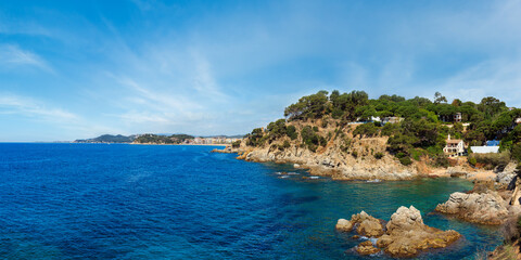 Fototapeta na wymiar Summer sea rocky coast view (near Lloret de Mar town, Catalonia, Spain). People unrecognizable.