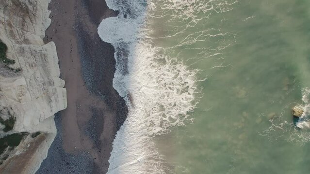 Aerial of impressive Normandy's white cliffs, round pebbles beaches and green pasture on the Alabaster Coast, France, 4K drone