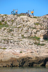 Image of 2 retro-style bicycles parked in a picturesque and relaxed natural environment