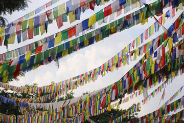 Colorful fabrics hanging from cables with the sky in the background