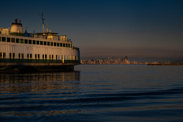Obraz premium 2021-09-02 A WASHINGTON STATE FERRY POINTED TOWARDS THE SEATTLE SKYLINE AND STADIUMS AT DUSK ON THE PUGET SOUND