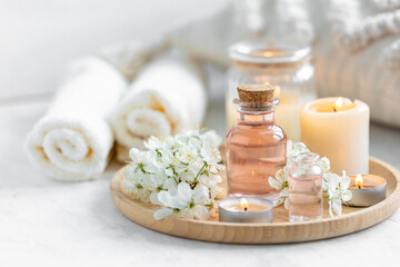 Fototapeta na wymiar Concept of pure natural organic ingredients, flowers, herbal extracts in cosmetic beauty products. Perfumery, home fragrance with the scent of blooming spring flowers. Candles, bamboo tray