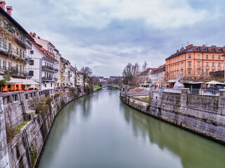 Fototapeta na wymiar Ljubljana river and riverside historic buildings on a cloudy afternoon, Slovenia