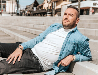 Portrait of a handsome hipster man in a jean jacket. A man in a big city on the street, a life style concept