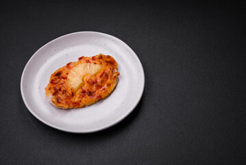 Grilled chicken fillet in the form of a steak with tomatoes, pineapple and cheese