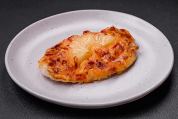 Grilled chicken fillet in the form of a steak with tomatoes, pineapple and cheese