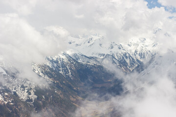 Naklejka premium Ascent to Pastukhova Mountain on Arkhyz. Snow-capped mountains with low clouds