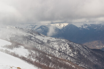 Obraz premium Ascent to Pastukhova Mountain on Arkhyz. Snow-capped mountains with low clouds