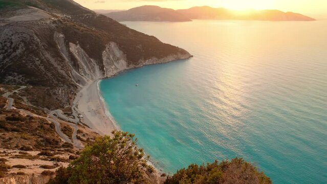 Woman watching sunset over the famous Myrtos beach on Kefalonia island, Greece