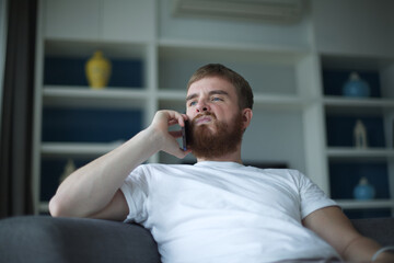 Portrait of young angry sad upset frustrated man, dissatisfied unhappy guy talk, swear on cell...