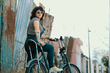 Retrato de mujer joven a la moda en bicicleta - obrazy, fototapety, plakaty