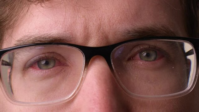 Man with pink eye in both eyes puts on dirty glasses - close up on eyes