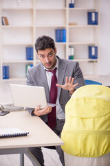 Young male employee looking after newborn at workplace