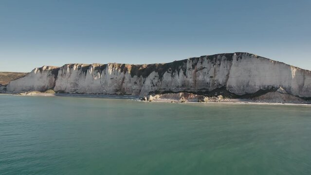 Aerial of impressive Normandy's white cliffs, round pebbles beaches and green pasture on the Alabaster Coast, France, 4K drone