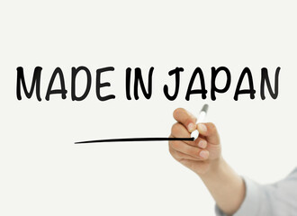 Businessman writing "Made in Japan" on a transparent board
