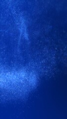 Obraz premium Vertical festive Christmas Holidays and seasonal winter and New Year stars particle background. Blue 3D illustration GUI phone wallpaper. Swirling underwater motion of glamorous elegant glowing snow.