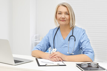 Doctor sitting at white table in clinic