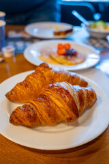 Two fresh baked puff croissants, traditional French breakfast