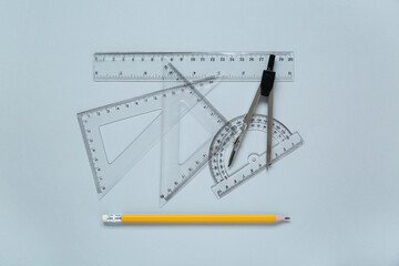 Different rulers with measuring length markings and compass on light grey background, flat lay