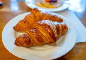 Two fresh baked puff croissants, traditional French breakfast