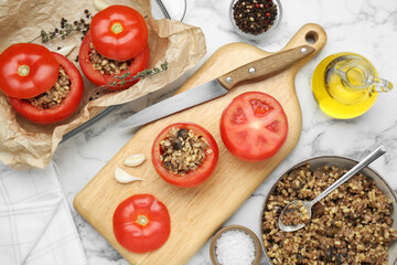 Preparing stuffed tomatoes with minced beef, bulgur and mushrooms on white marble table, flat lay