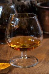 Tasting of aged french cognac brandy alcoholic drink in old cellars of cognac-producing regions Champagne or Bois, France