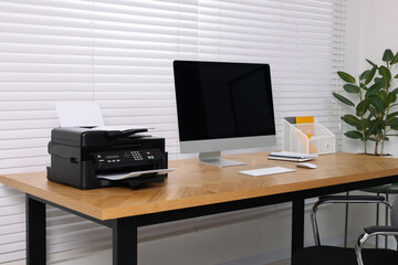 Stylish room interior with desk, modern printer and computer