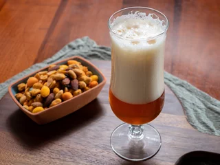 Rolgordijnen Glass of Belgian light blond beer made in abbey and bowl with party mix nuts © barmalini