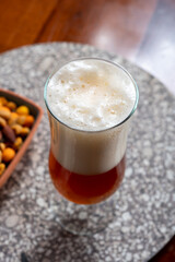 Glass of Belgian light blond beer made in abbey and bowl with party mix nuts