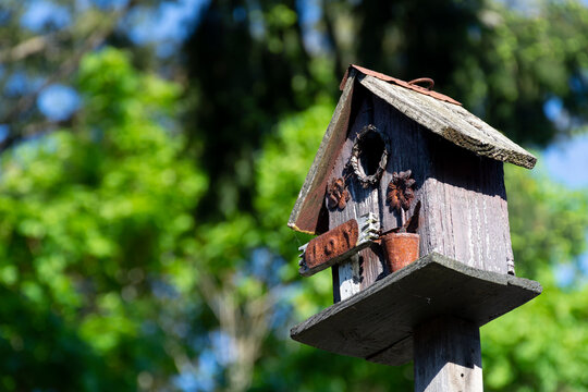 An image of an old handmade wooden birdhouse decorated in a vintage style.