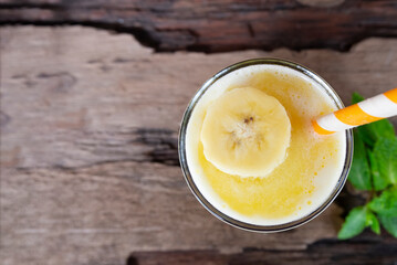 Banana fresh cocktail vanilla smoothies  fruit juice beverage healthy the taste yummy in glass drink episode good morning on wooden background from the top view.