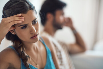 Unhappy, upset or sad with a couple arguing on a sofa in their home living room about an affair or...