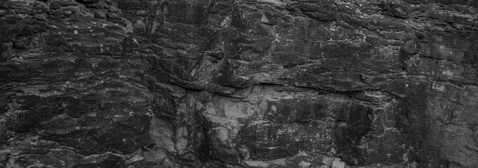 Obraz premium A captivating black rock background with a dark gray stone grunge texture, creating a visually stunning and textured backdrop.