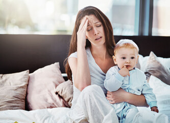 Mother, baby and tired or stress in a home bedroom or bed with postpartum, headache or anxiety....