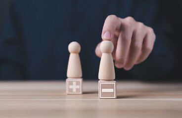 Block people show plus and minus symbols. The concept of opposites, decisions, and uncertainty....