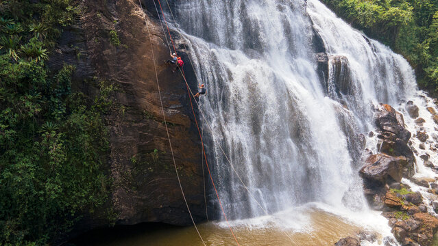 Tr&ecirc;s pessoas fazendo rapel em cachoeira, Minas Gerais