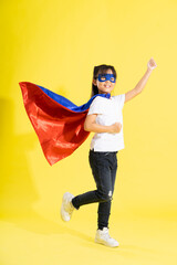 Portrait of little girl dressed up as a hero, isolated on yellow background