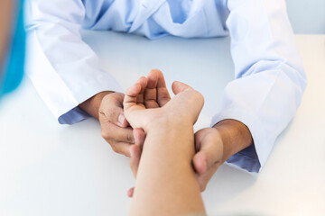 Doctor in white gown or uniform did examination on patient's hand or wrist at hospital.Orthopedist holding woman's hand.Doctor care patient with pain problem in orthopedic unit.Asian man. - Powered by Adobe