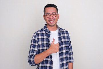 Adult Asian man smiling and give thumb up to the camera