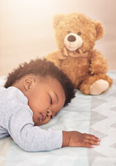 Sleeping, teddy bear and dreaming with baby in bedroom for carefree, development and innocence. Cute, relax and comfortable with african infant and toy resting at home for morning, nap and bedtime