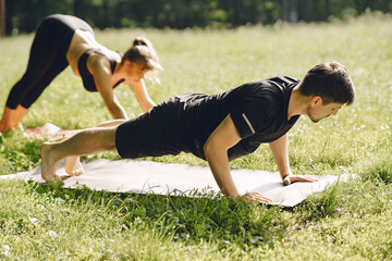 Man and woman doing yoga exercises in the park