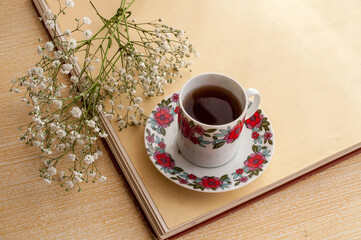 Cup of tea with flowers on a wooden table. Selective focus.