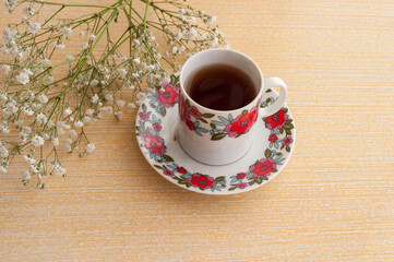 Cup of tea with flowers on a wooden table. Selective focus.