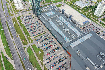 aerial view of shopping mall with crowded parking lot and highway nearby