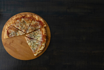 Tasty 4 cheese pizza on a wooden base